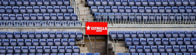 a stadium with blue seats and a red sign